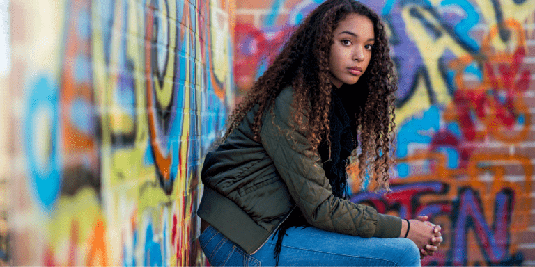 Young woman sitting, staring at the camera