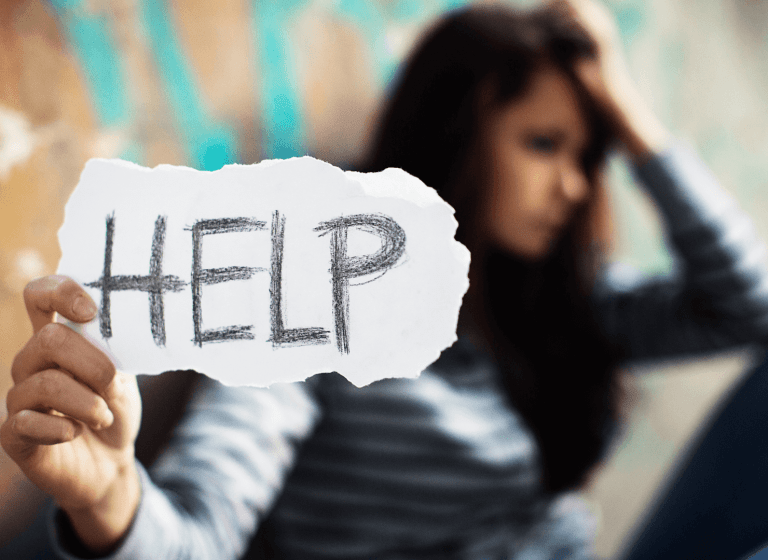 A woman holding a sign that says HELP